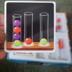 Dr. Eureka card showing three test tubes with colored balls
